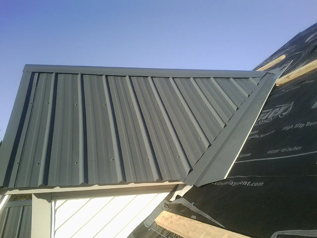 Gray metal roof panels going on over a garage gable in Bethel Park