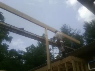 Carpenter setting a ridge beam over a new addition frame — Ice Dam Removal by Roofing Brothers in Bethel Park