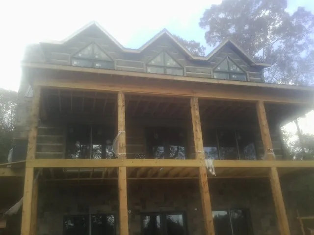 Dormers and porch framing on a large log home under construction — Roof Coating work by our crew in Bethel Park